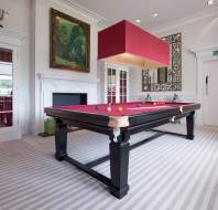 Red baize billiard table in a cozy room