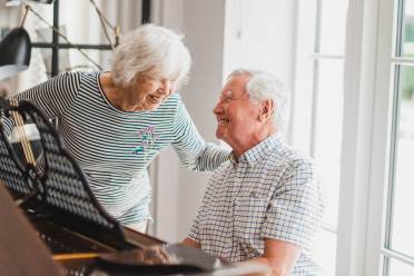 Retired people playing piano and laughing