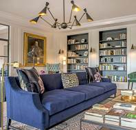 Long blue sofa with book shelves and painting