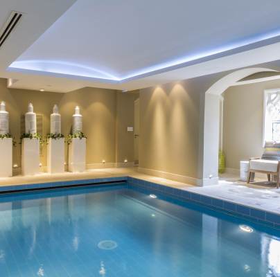 Blue indoor pool in calm surroundings with mood lighting