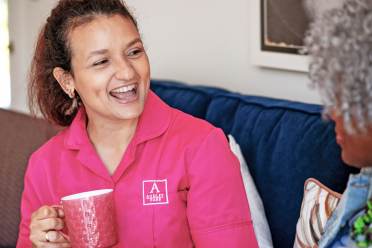 Woman enjoys coffee and chat with carer